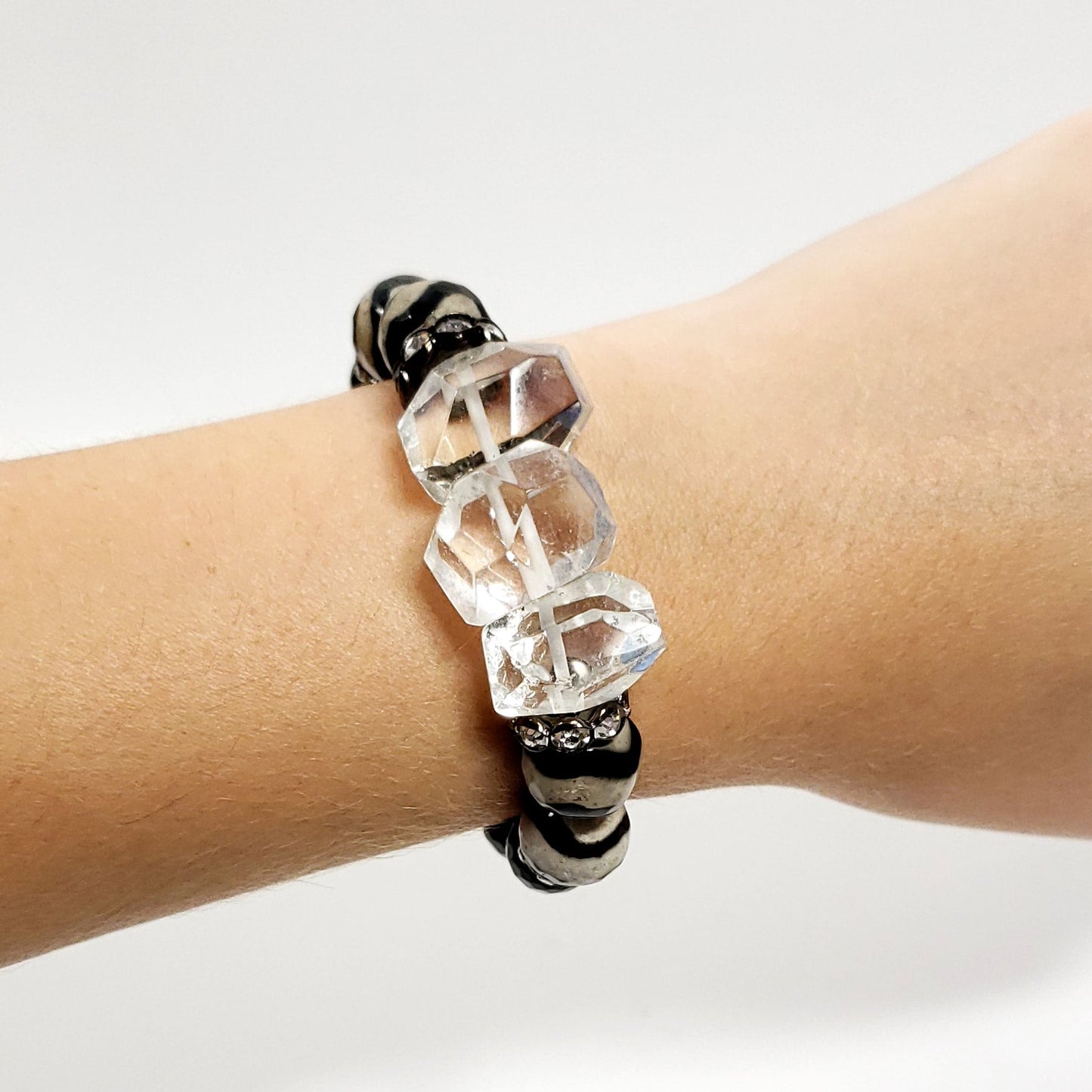Bracelet with clear beads on a wrist against a white background