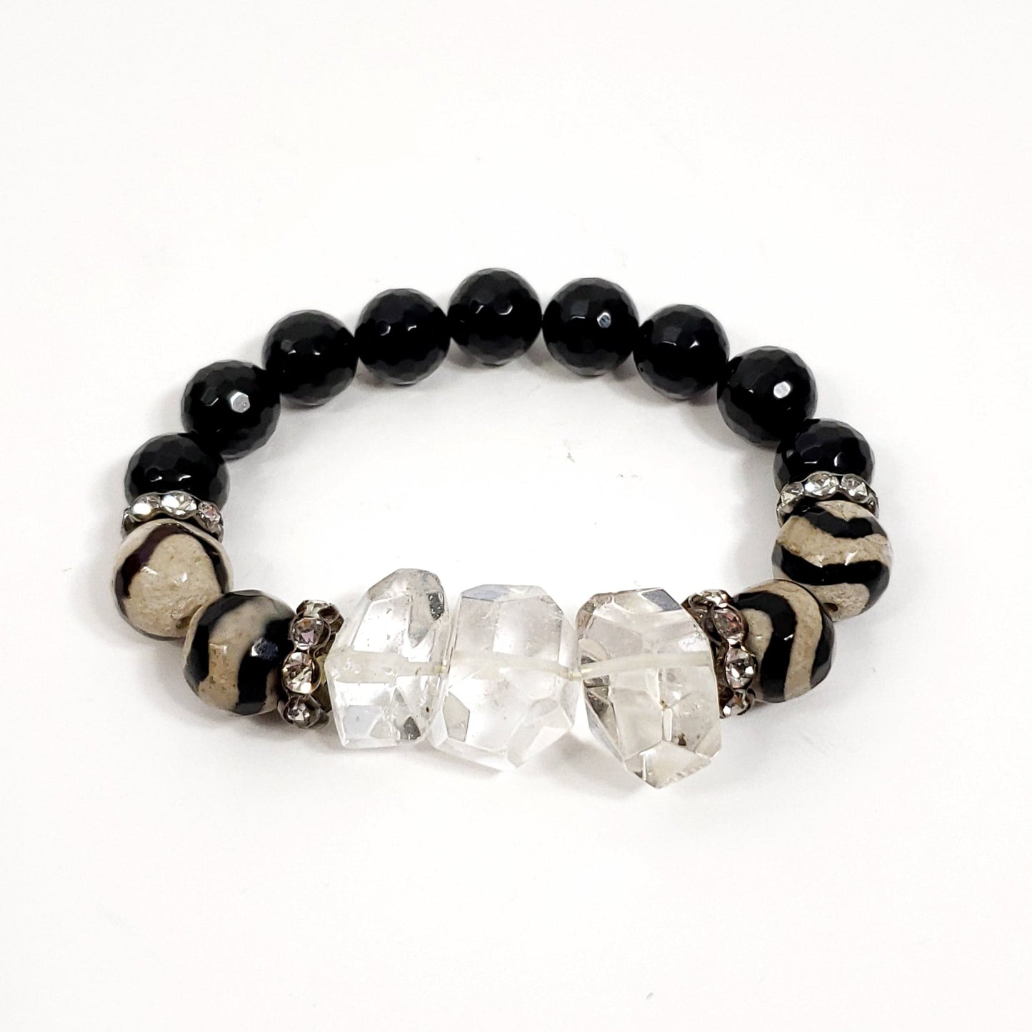 Bracelet with black beads, clear crystals, and a zebra-patterned band on a white background
