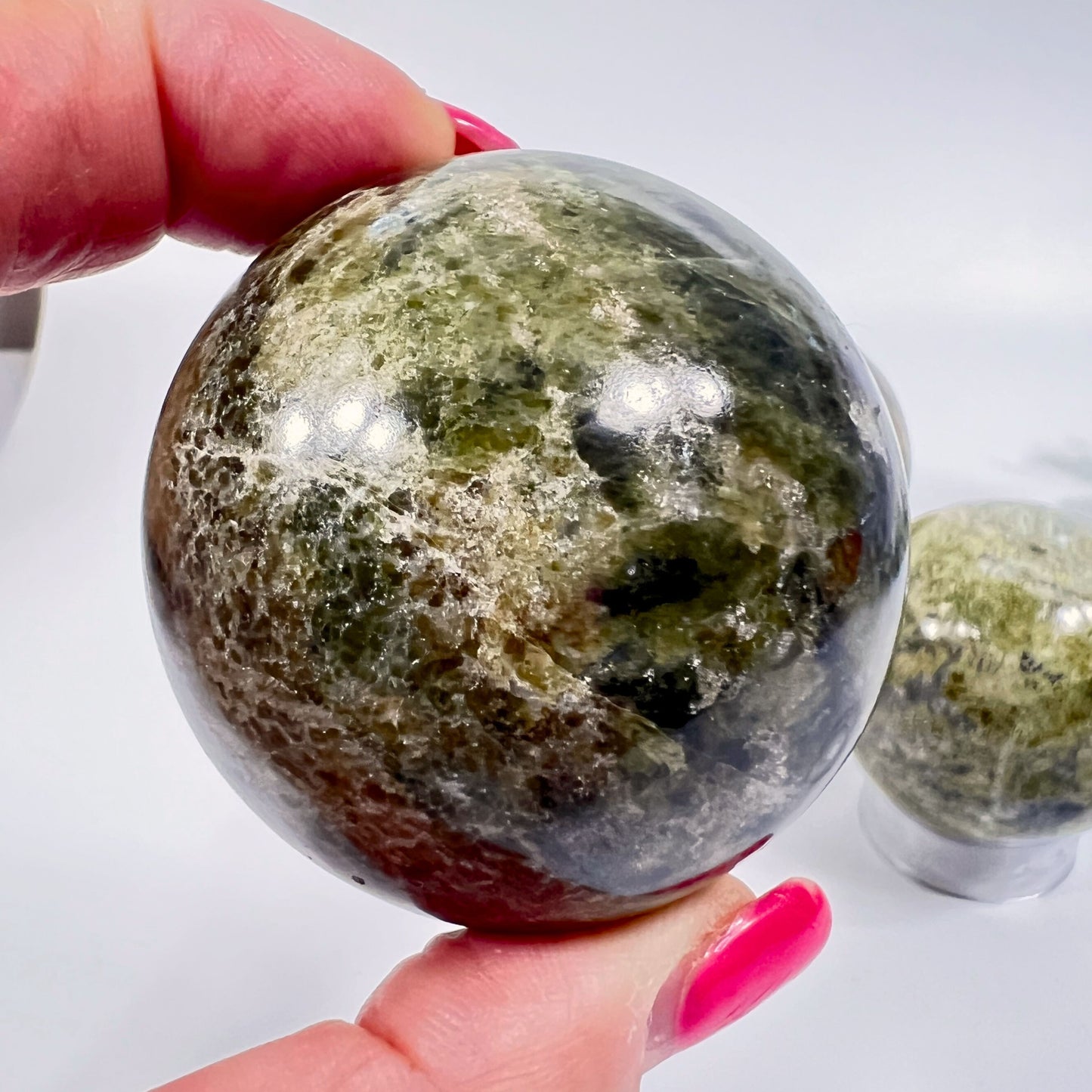 Person holding a large crystal ball with another crystal ball in the background