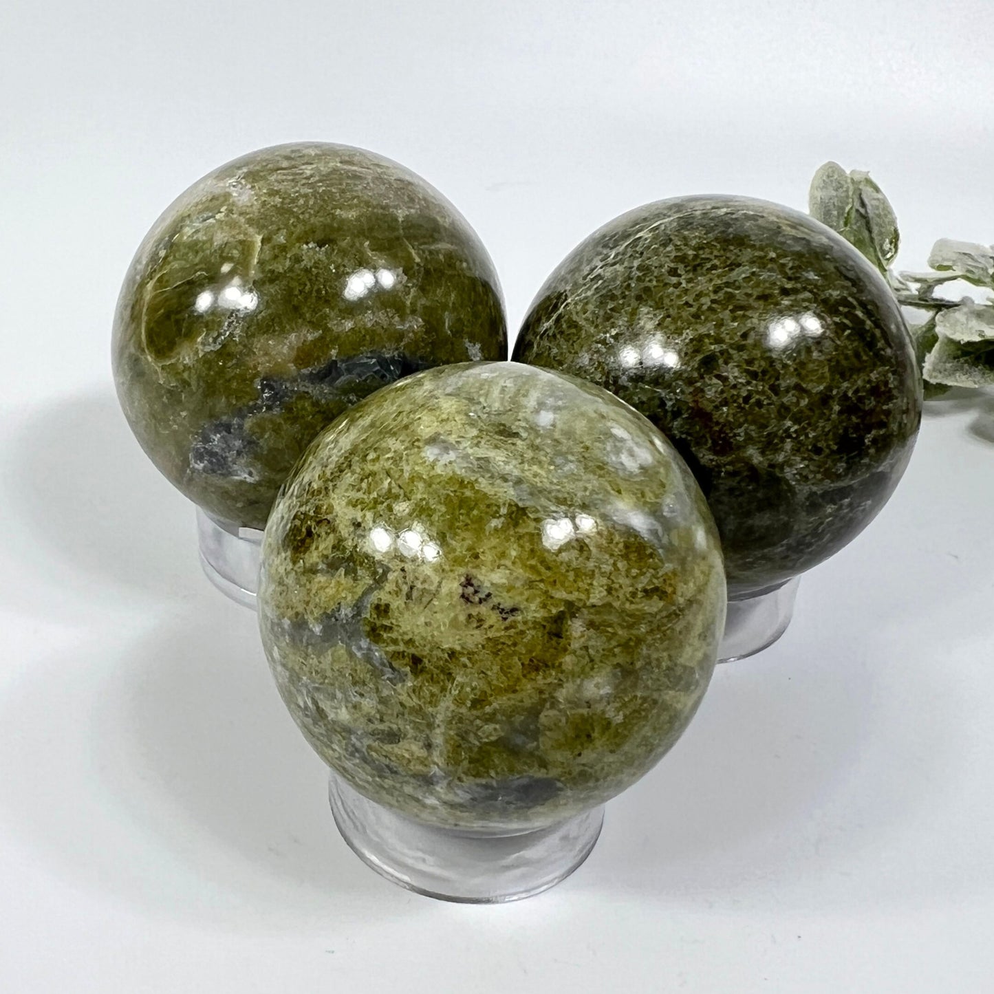 Three green marbled spheres on a white background