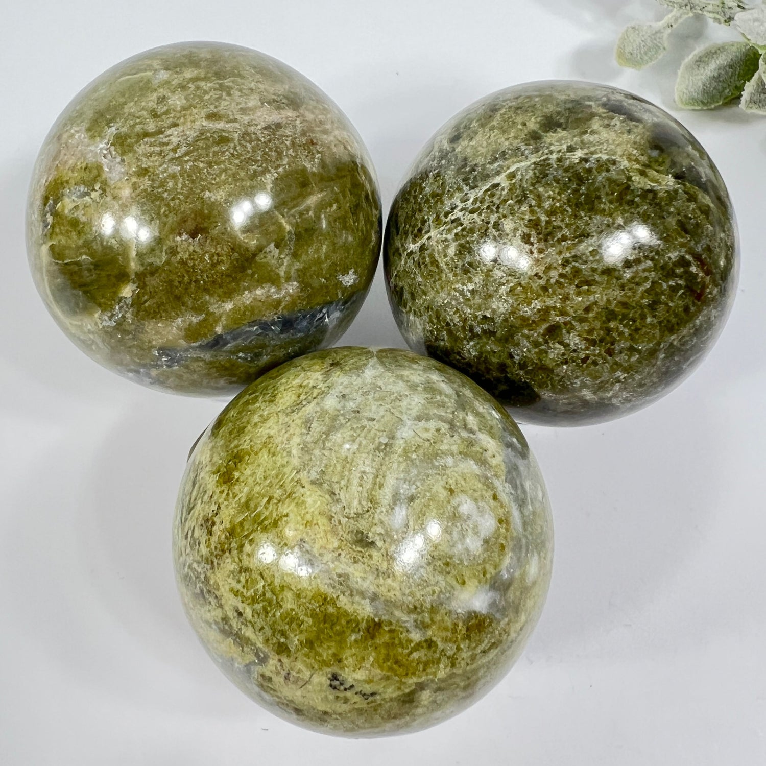 Three green marbled stones on a white background