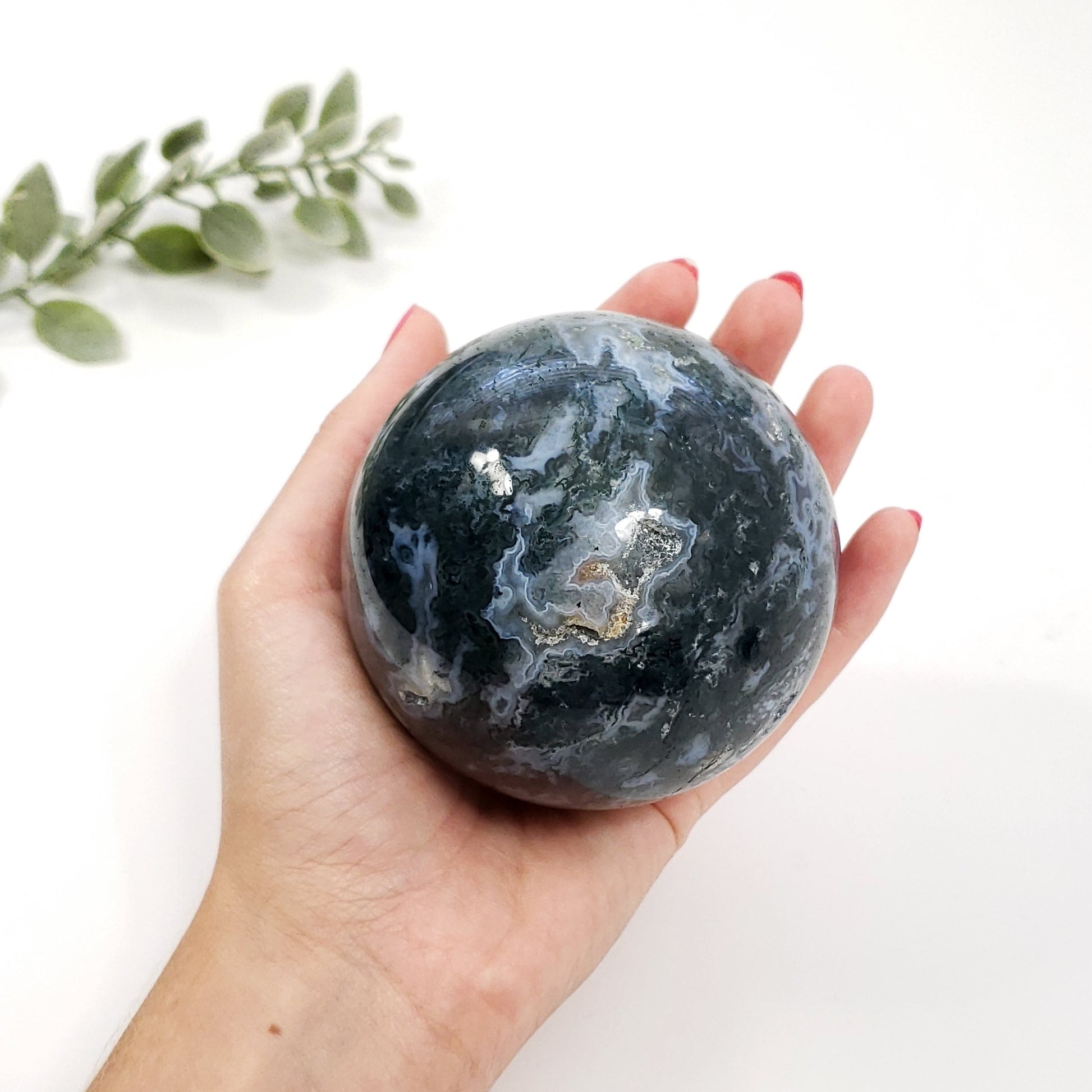 large Green moss agat sphere in ladies hand