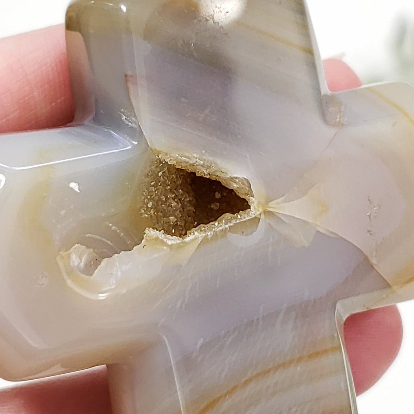 Close-up of a semi-precious stone with a central cavity held between fingers.