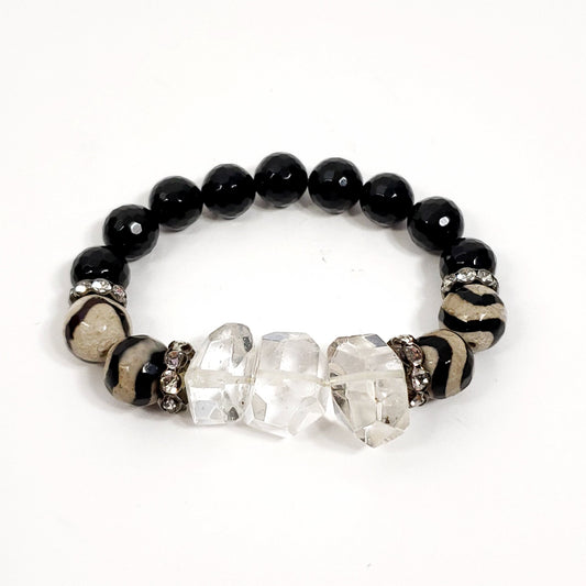 Bracelet with black beads, clear crystals, and a zebra-patterned band on a white background