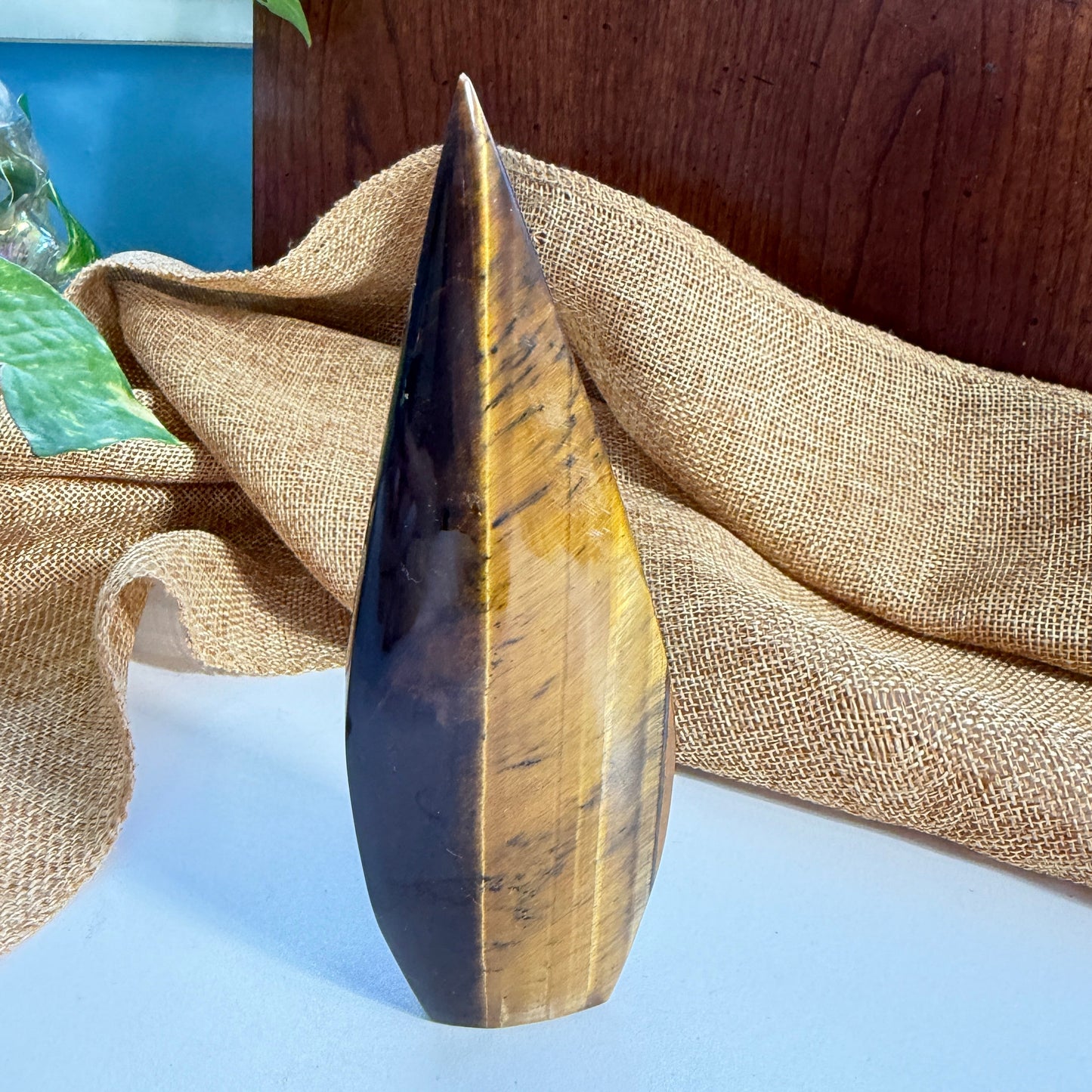 Close-up view of Golden Tiger Eye Flame crystal displaying warm earthy tones and flowing golden striations