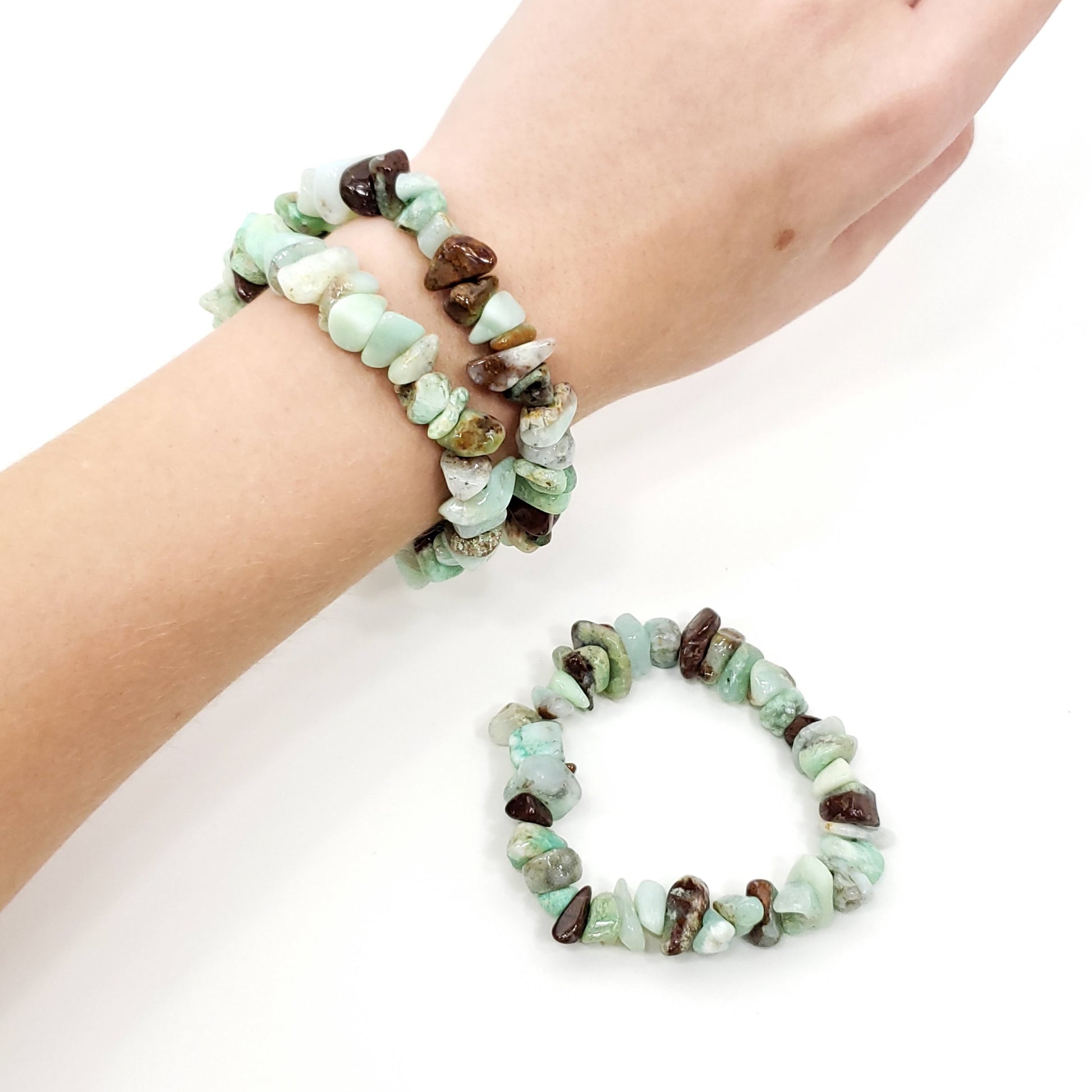 A pair of stretch bracelets made of polished natural stone chips in mint green, brown, and cream, shown worn on a wrist and laid flat on a white background.
